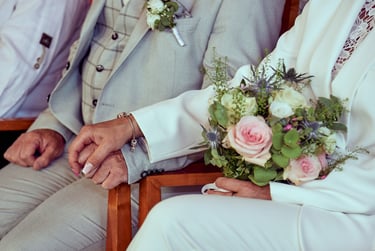 Braut und Bräutigam halten sich während einer Hochzeitszeremonie an den Händen.