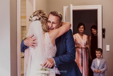 Der Vater der Braut umarmt seine Tochter.