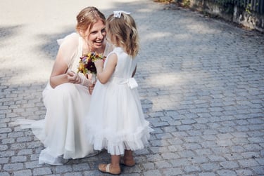 Bride showing flowers to a girl.