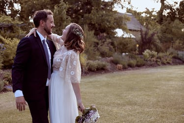 Bride and groom hugging in a garden.