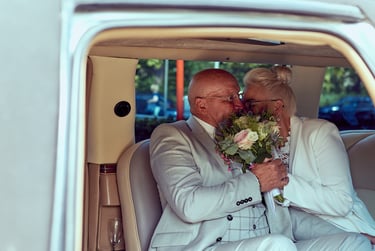 Bride and groom kissing in a car.