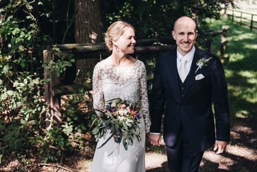 Bride and groom walking in the countryside.
