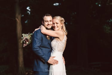 Portrait of bride and groom hugging and laughing.