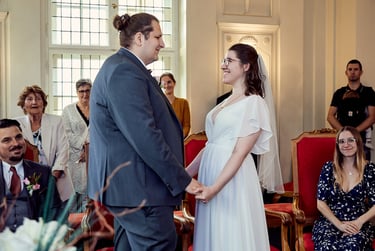Bride and groom smiling at each other during a civil wedding ceremony.