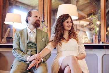 Bride and groom holding hands and smiling during civil ceremony.