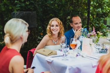 Smiling bride and groom sitting at a table.