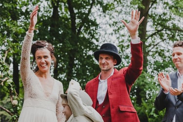Bride and groom raising their hands in celebration after the ceremony.