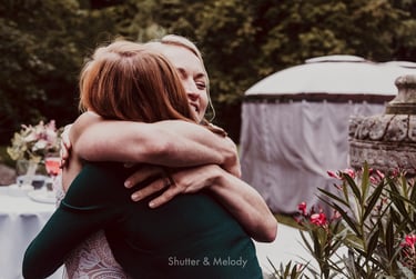 Bride hugging female wedding guest.