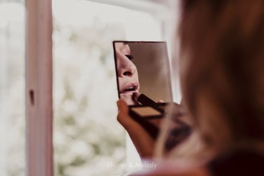 Bride using pencil on her lips.