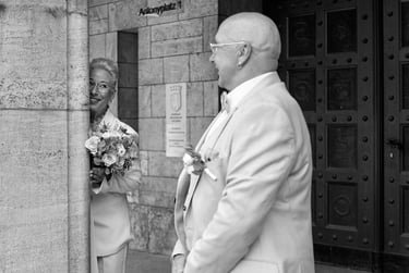 Bride peeking at the groom from behind a column.