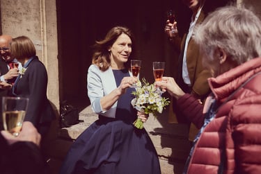 Bride toasting guest outside.