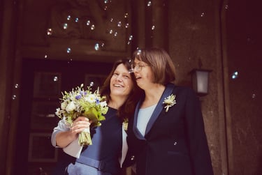 Two happy brides standing outside after civil ceremony.