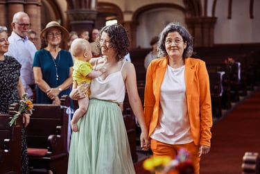 Two brides walking in church with a baby.