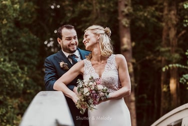 Bride and groom on a bridge laughing.