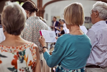Wedding guest singing holding a songbook.