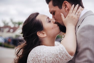 Bride kissing husband while holding his face.