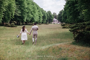 Bride and groom walking in a meadow.