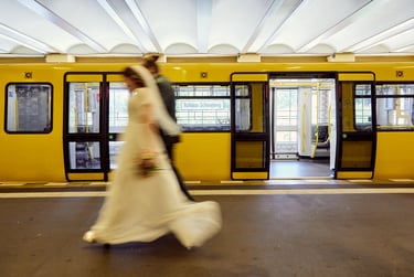Bride and groom walking past and underground carrige in Berlin.