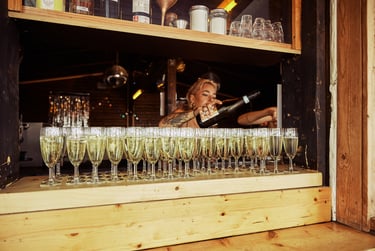 Der Barkeeper schenkt Champagner in Gläser ein.