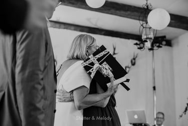 Bride hugging wedding guests after receiving a gift box.