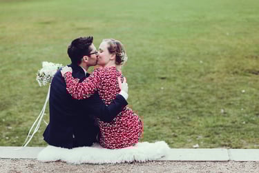 Bride and groom kissing while sitting on a sheep skin.