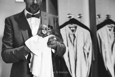 Groom cleaning his corsage with a towel.