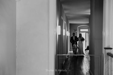 Father of the bride awlking his daughter in a corridor.