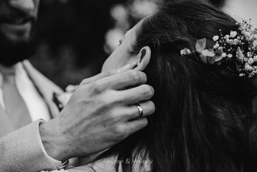 Close-up of groom touching bride's ear.