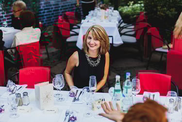 Hochzeitsgast sitzt am Tisch und lächelt.