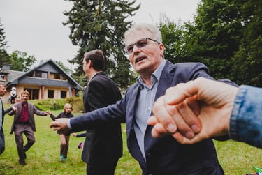 Hochzeitsgäste tanzen Hand in Hand im Kreis. 