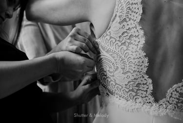 Braut wird beim Schließen ihres Reißverschlusses geholfen.