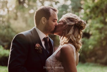Bride and groom sharing a kiss in a forest.