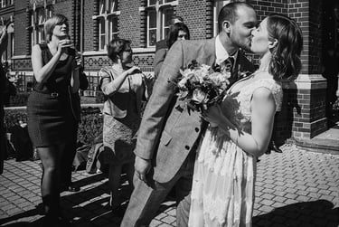 Groom kissing bride after exiting civil registry.