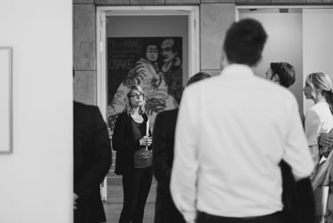 Museumsführer im Gespräch mit Besuchern während einer Führung in einer Kunstgalerie.