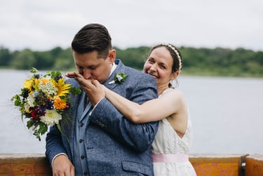 Groom kissing the laughing bride's hand.