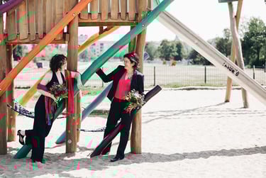 Two laughing brides at a playground.