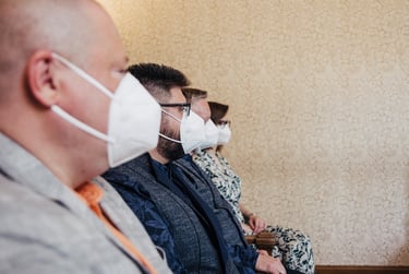 Profiles of grooms and their wedding guests wearing white masks.
