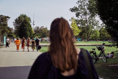 Wedding guests walking in Mauerpark with TV tower in the distance.