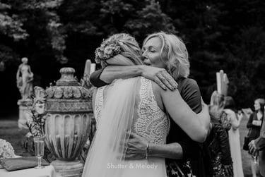 Mother of the bride hugging daughter.