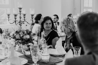 Wedding guest talking to another while sitting at the table.