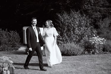 Young married couple walking in a garden.