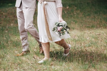 Bride and groom walking on a meadow.