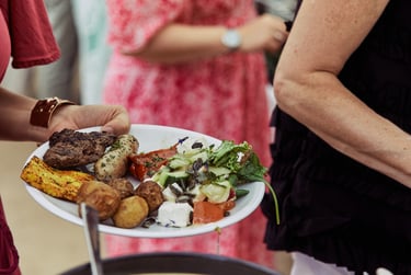Wedding guest holding a plate with a selection of food.