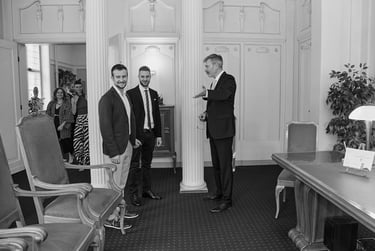 Civil registrar showing seats to a young gay couple.