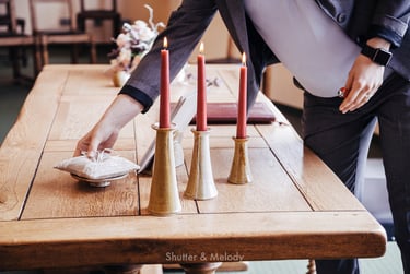 Wedding officiant placing a pillow with rings on a table.