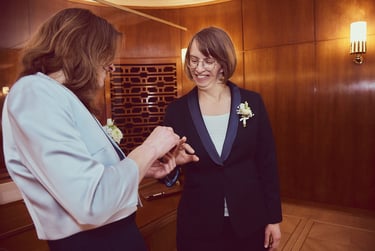A newly wed lesbian couple exchanging wedding rings.