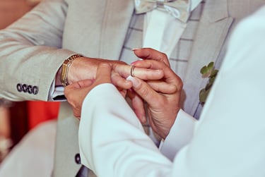 Die Ehefrau steckt ihrem Mann einen Ring an den Finger.