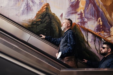 Zwei Bräutigame fahren auf der Rolltreppe.