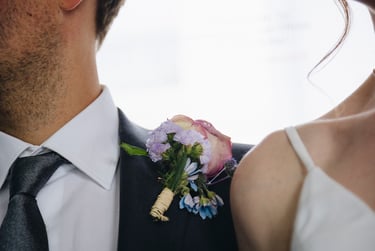 Bride's and groom's shoulders with flowers in the middle.