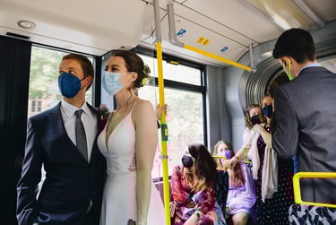 Braut und Bräutigam in der Straßenbahn mit Masken.